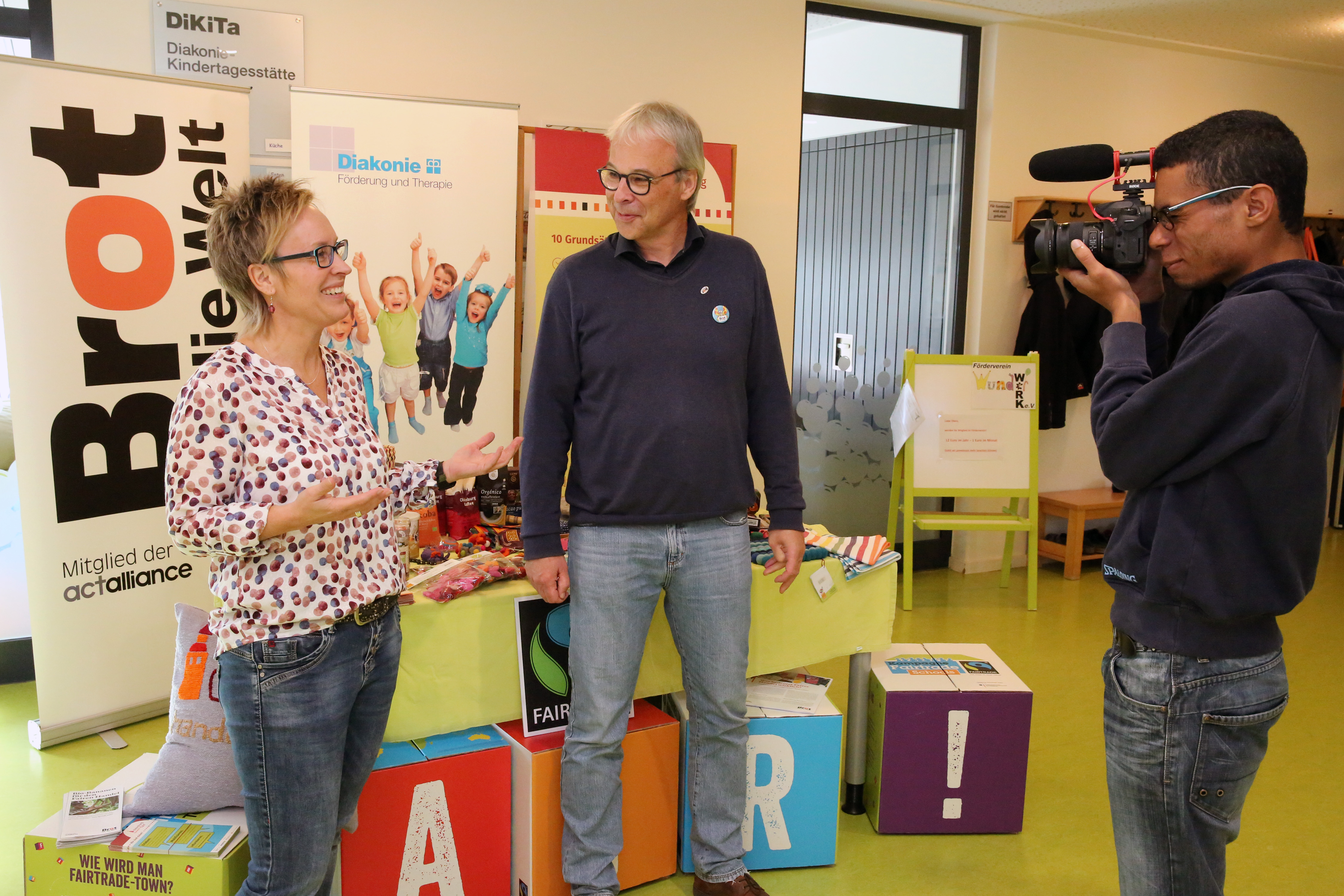 DiKita-Leiterin Nicole Eilers (li.) und Marius Blümel erklären die Hintergründe der Bananenbrot-Backaktion.